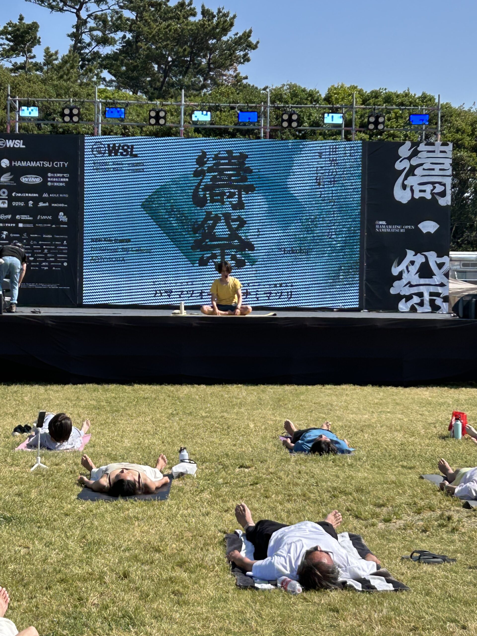 AOTOSORAの芝生の上で参加者が仰向けになって休むヨガの最後の時間